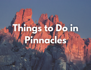 Pinnacles National Park 5 Sun sets on the rock spires of Pinnacles National Park, casting a deep red glow. Text over the photo reads, "Things to Do in Pinnacles"