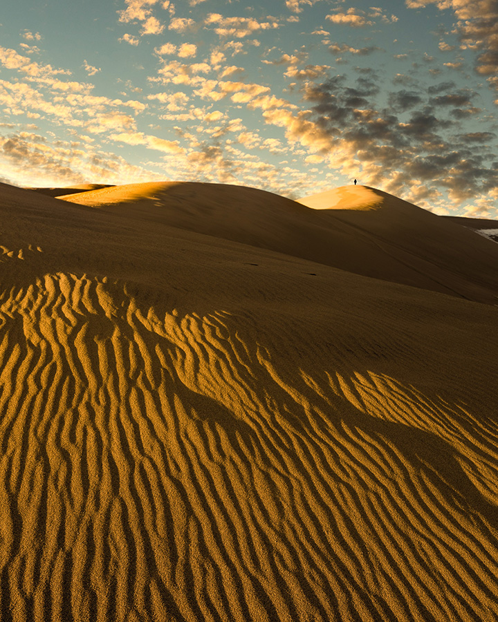 Great Sand Dunes Itinerary: One Day in Great Sand Dunes National Park 10 Sand dunes against a partly cloudy sky at sunset