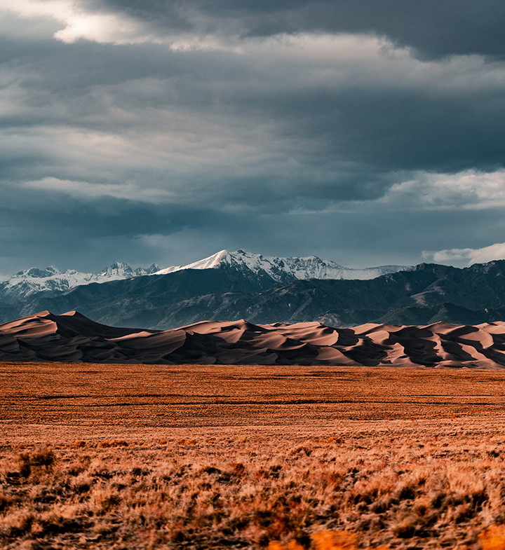 Great Sand Dunes Itinerary: One Day in Great Sand Dunes National Park 3 Large sand dunes in the foreground with a mountain range in the background