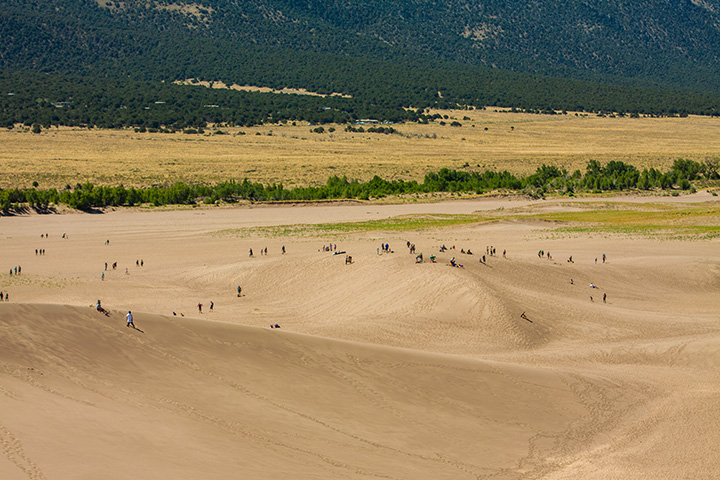 Great Sand Dunes Itinerary: One Day in Great Sand Dunes National Park 9 People dot a series of sand dunes above a meadow