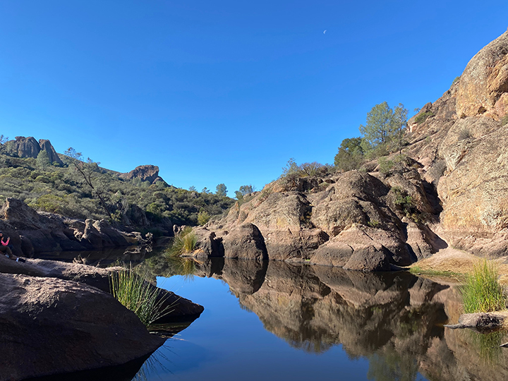 The Ultimate Pinnacles National Park Camping Guide 3 A small lake with surrounding rocks reflected in the water