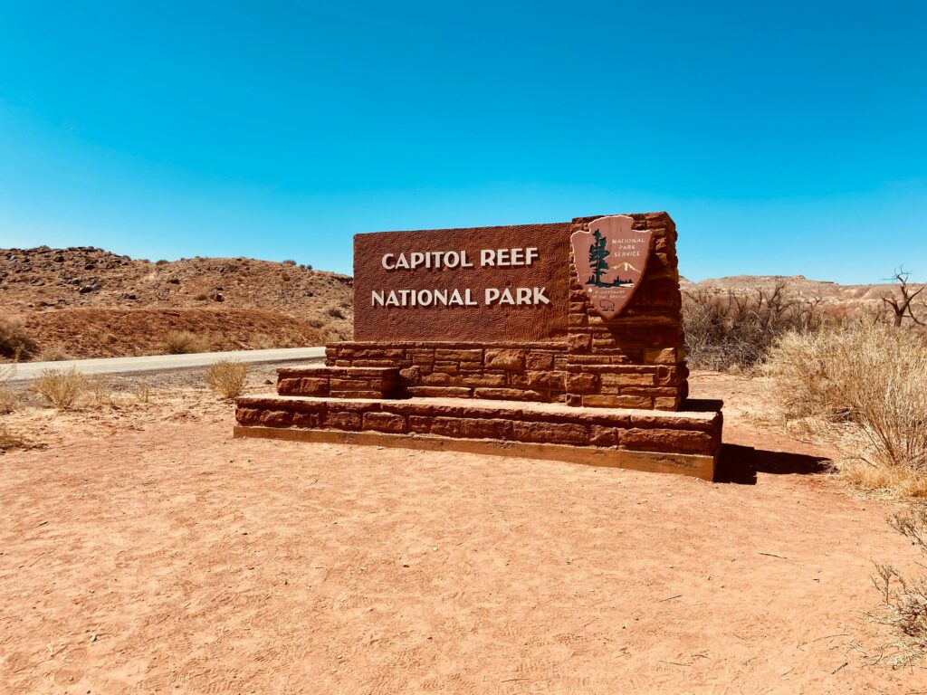 20 Best Hikes in Capitol Reef National Park 35 An orange sign sits on a cleared out dirt circle welcoming people to Capitol Reef National Park