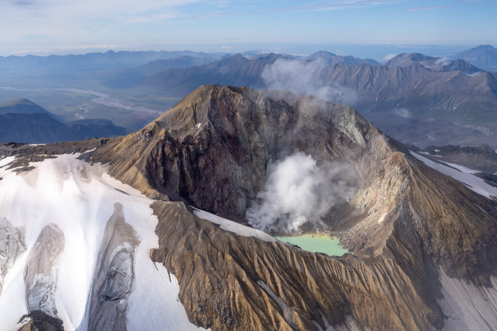 The 13 Best Things to Do in Katmai National Park: Bears and Volcanoes Galore 21 A view of a mountain with a lake inside its crater from a plane; flightseeing is one of the best things to do in Katmai National Park