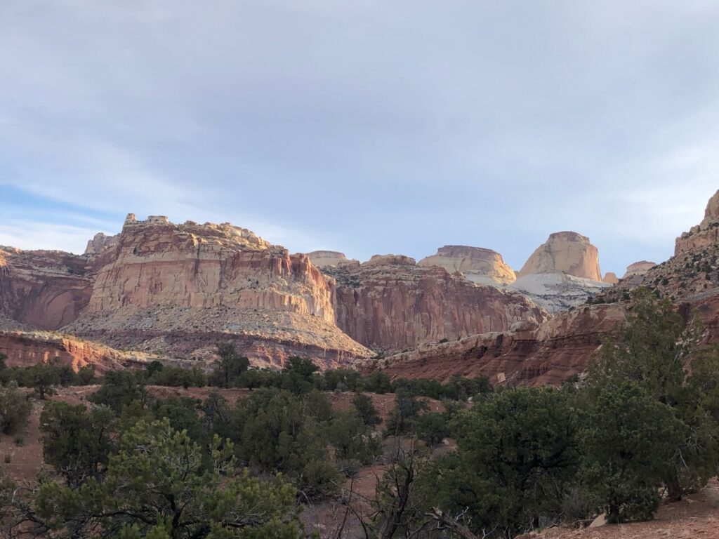 20 Best Hikes in Capitol Reef National Park 27 Yellow and orange rock formations below a gray sky