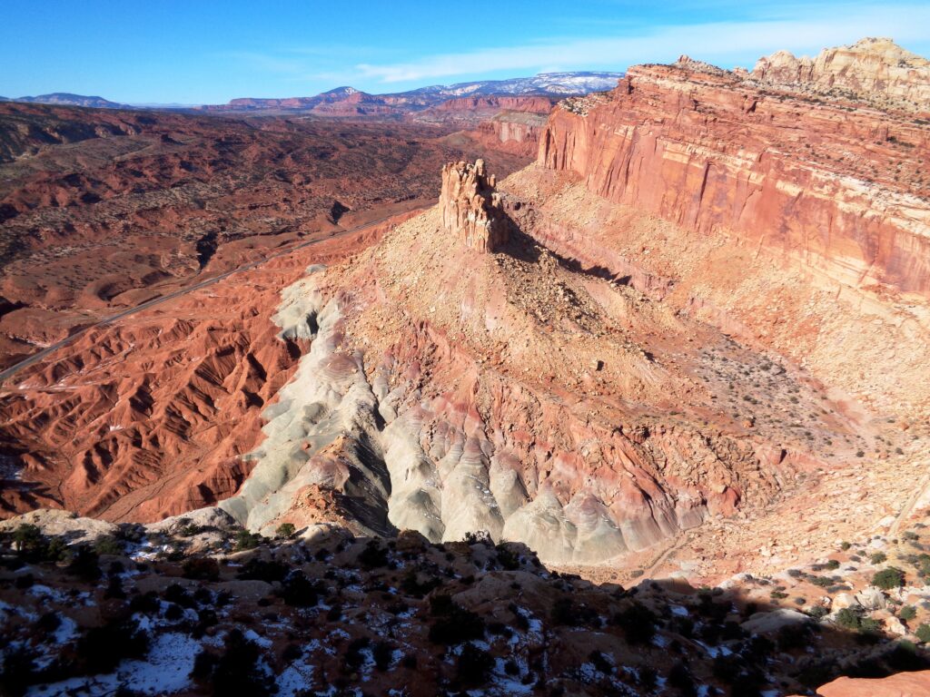 20 Best Hikes in Capitol Reef National Park 34 A tall, cylindric rock formation rises from the center of a red canyon