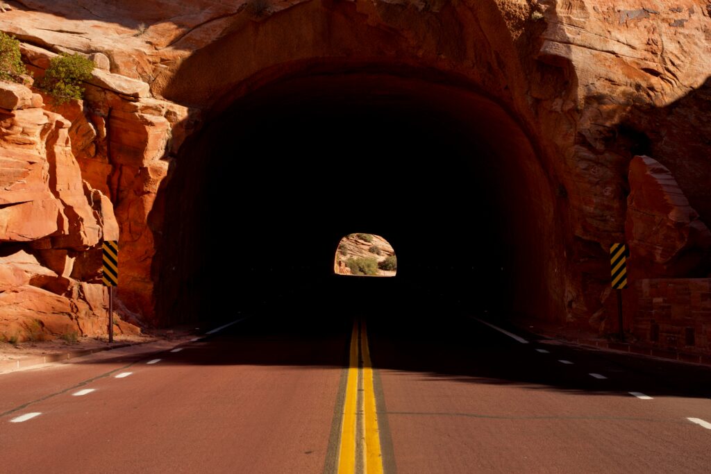 Closest Airports to Zion National Park: How to Get to Zion National Park, Utah 9 A paved road leads into a shadowed tunnel