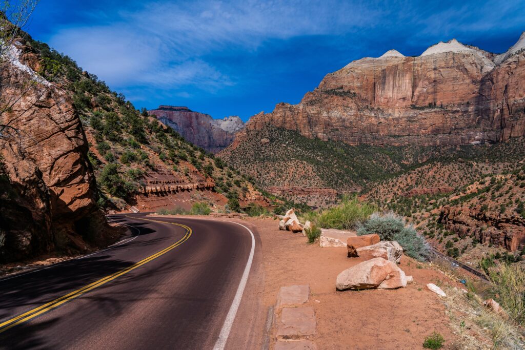 Closest Airports to Zion National Park: How to Get to Zion National Park, Utah 12 A paved road rounds a bed through orange rock formations | Closest Airports to Zion National Park | How to Get to Zion National Park