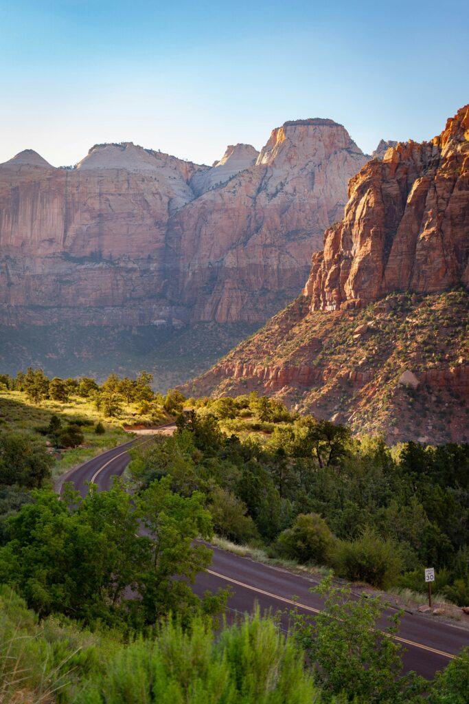 Closest Airports to Zion National Park: How to Get to Zion National Park, Utah 7 A paved road runs through green trees below towering rock formations