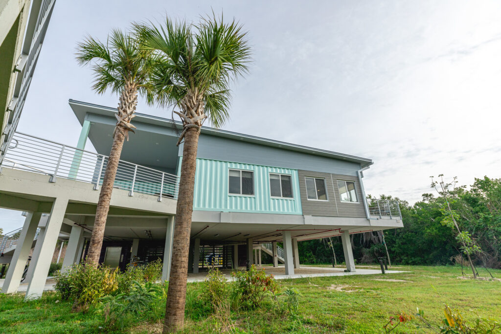 Everglades National Park Camping Guide: Everything You Need to Know 25 Two palm trees in front of the blue and gray Flamingo Lodge, one of the options if you aren't up for camping in Everglades National Park.