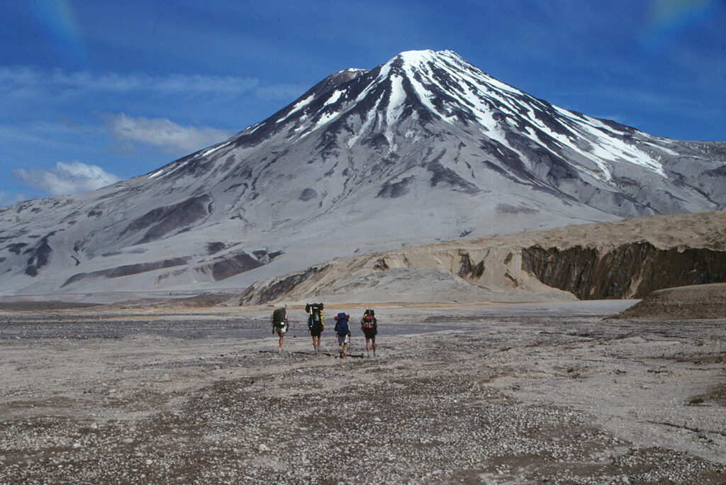 Where to Stay in Katmai National Park: Lodging, Campgrounds, and Backpacking 7 Four hikers walk toward Mount Griggs in the backcountry of Katmai National Park